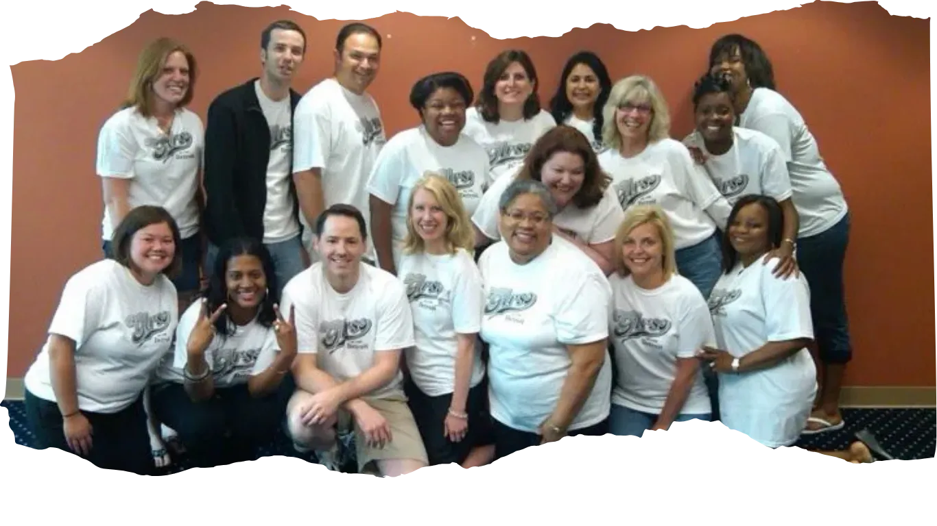 Diverse group of people smiling in matching custom T-shirts, showing unity and team spirit