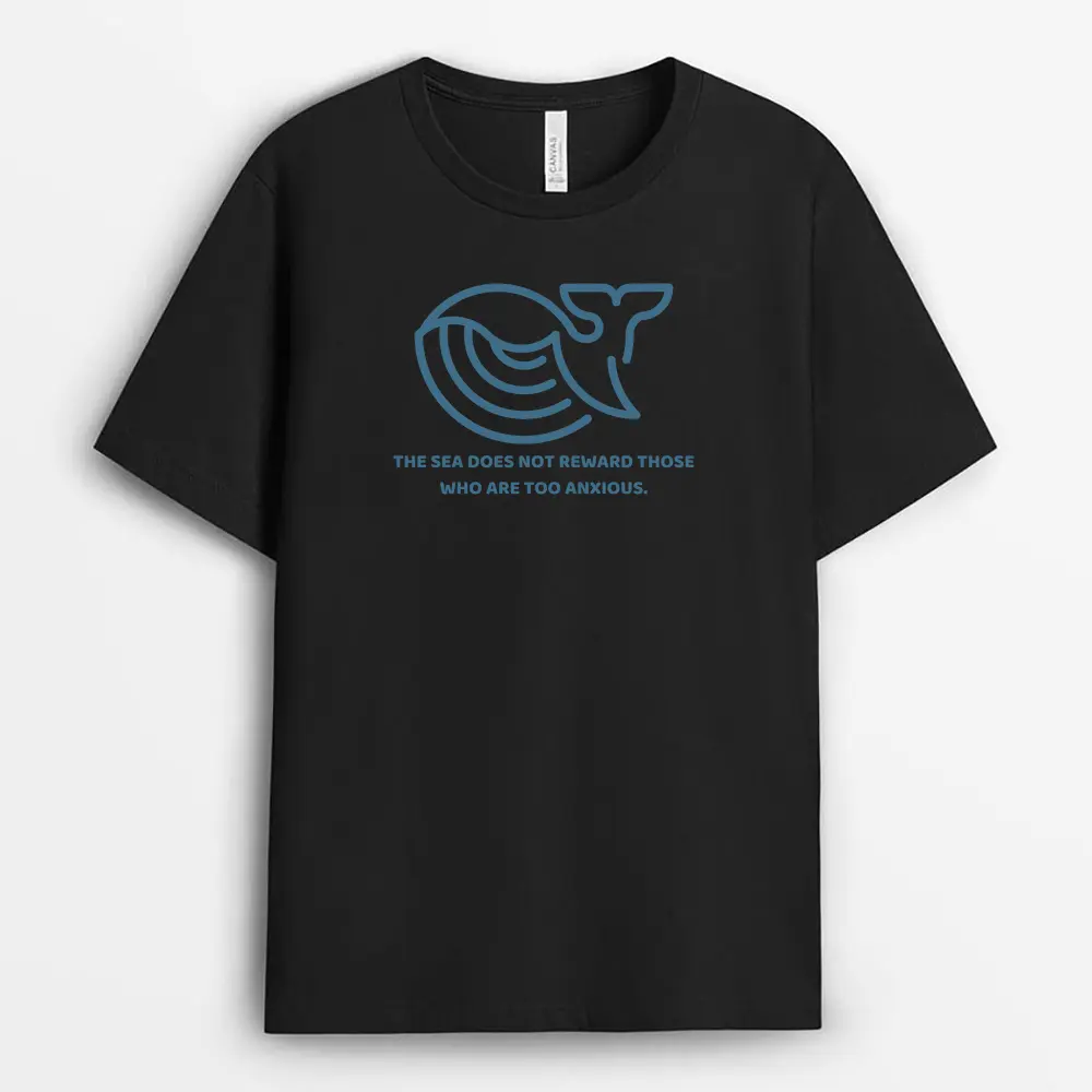 Neutral-toned T-shirt laid over driftwood, displaying a bold sea quote in sharp typography over soft organic cotton, perfect for coastal-themed fashion.