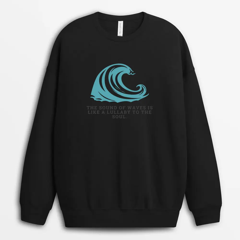 Portrait of a model gazing out to sea wearing a sand-colored sweatshirt with layered wave textures printed across the front, embodying quiet strength and peace.